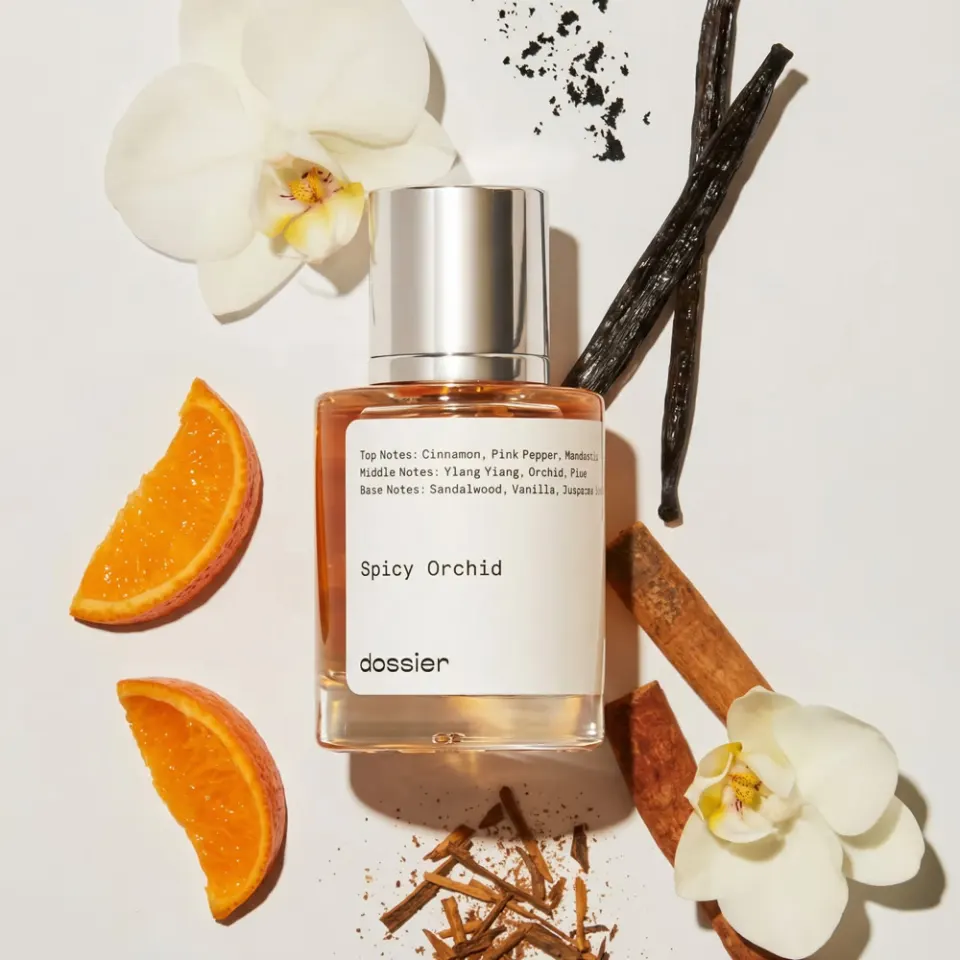 Dossier perfume flat lay with oranges and orchids
