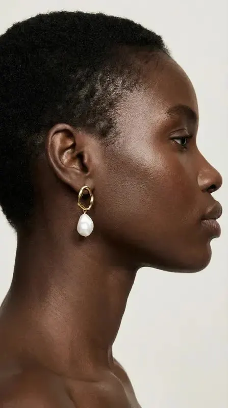 Profile of a woman wearing a pearl drop earring